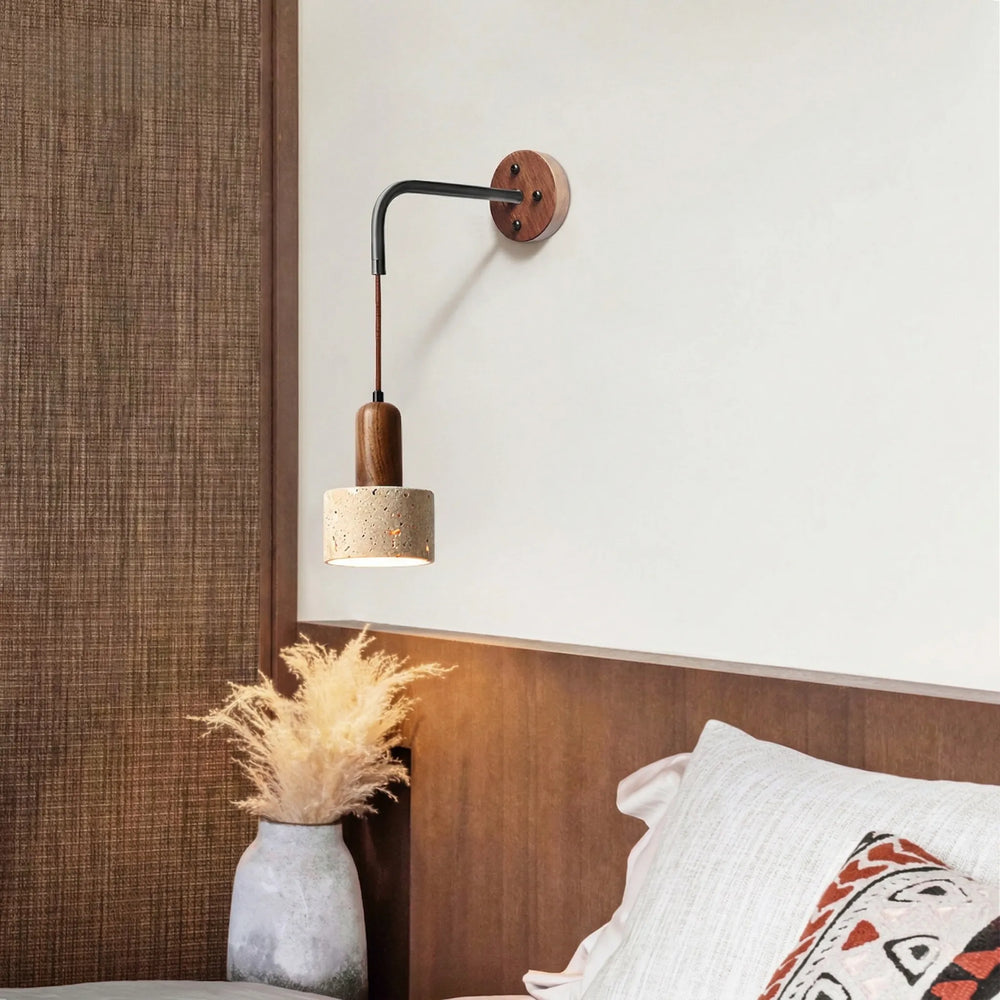 Wall-mounted lamp with wooden fixture and concrete base in a bedroom setting.